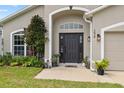 Close-up of the home's front entrance, highlighting the black door and well-kept landscaping at 298 Clydesdale Cir, Sanford, FL 32773