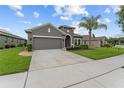 View of the charming single-story house featuring a well-kept lawn and a paved driveway at 3349 Sagebrush St, Harmony, FL 34773