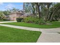 Side view of house with well maintained green lawn and mature shrubbery at 4823 Shoreline Cir, Sanford, FL 32771