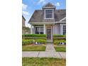Inviting townhome showcasing a well-manicured front yard, a stylish front door, and classic architectural details at 6527 Silver Queen Way, Windermere, FL 34786
