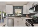 Modern kitchen with stainless steel appliances, white cabinetry, subway tile backsplash, and lots of natural light at 719 Stevelynn Cir, Winter Garden, FL 34787
