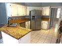 Bright kitchen featuring stainless steel appliances, granite countertops, and ample cabinet space at 8025 Old Town Dr, Orlando, FL 32819