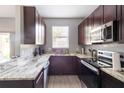 Modern kitchen features stainless steel appliances, granite countertops, and stylish dark wood cabinetry at 936 Calabria Ave, Davenport, FL 33897