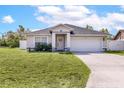 Charming single-story home with a well-maintained lawn, gray color scheme and attached two-car garage at 999 Trumbull St, Deltona, FL 32725