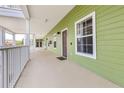 Exterior walkway showing light green siding, white railings, and brown doors with secure residential living at 110 Watling Way # 25204, Davenport, FL 33837