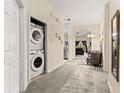 Inviting home hallway featuring a laundry closet and flows into living space with carpet flooring at 110 Watling Way # 25204, Davenport, FL 33837