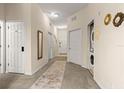 Hallway with neutral tones, carpet flooring, and multiple doors to other rooms, offering a welcoming entry at 110 Watling Way # 25204, Davenport, FL 33837