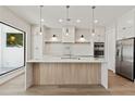 Spacious kitchen featuring a large center island, modern lighting, and stainless-steel appliances at 1217 Cloverlawn Ave, Orlando, FL 32806