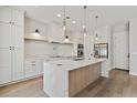 Well-lit kitchen showcasing a center island, white cabinets, and stainless-steel appliances at 1217 Cloverlawn Ave, Orlando, FL 32806