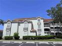 Exterior view of a condo building featuring a terracotta roof, stucco walls, and well-maintained landscaping at 13917 Fairway Island Dr # 931, Orlando, FL 32837