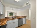 Bright kitchen with butcher block countertops and stainless steel dishwasher at 13917 Fairway Island Dr # 931, Orlando, FL 32837