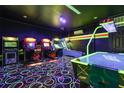 Fun-filled arcade room with classic arcade games, and a unique neon carpet at 1403 Rolling Fairway Dr, Davenport, FL 33896