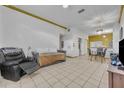 Bright living area with tile floors, comfortable seating, and dining area beneath a chandelier at 141 Reserve Cir # 113, Oviedo, FL 32765
