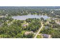 A captivating aerial view of a serene lake community with lush green trees and a charming neighborhood at 1601 Randolph St, Deltona, FL 32725