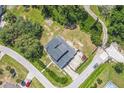 Aerial view of a residential home on a corner lot, surrounded by trees and well-maintained landscaping at 1601 Randolph St, Deltona, FL 32725