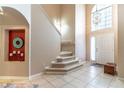 Elegant foyer with soaring ceilings, staircase and tile flooring that leads to the main living areas at 1933 Darlin Cir, Orlando, FL 32820