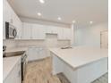 Open-concept kitchen featuring a large island, stainless steel appliances, and white cabinetry at 2500 Raghav Trail Cir, Tavares, FL 32778