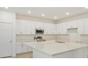 Bright kitchen with white cabinets, stainless steel appliances, a center island, and recessed lighting at 2500 Raghav Trail Cir, Tavares, FL 32778