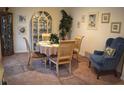Charming dining room with seating for four, lovely china cabinet, attractive wall art, and blue accent chair at 3074 Royal Tern Dr, Winter Haven, FL 33881