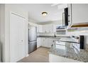 Modern kitchen featuring white cabinets, stainless steel appliances, and granite countertops at 340 Edgewood Ct, Kissimmee, FL 34759