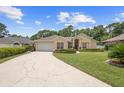 Traditional home with a lush lawn, driveway, attached garage, and manicured landscaping at 3593 Scoutoak Loop, Oviedo, FL 32765