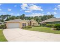 Charming one-story home with a manicured front lawn and a concrete driveway leading to an attached garage at 3593 Scoutoak Loop, Oviedo, FL 32765