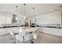 Bright, open kitchen featuring a large center island with bar seating, surrounded by white cabinets and stainless steel appliances at 5081 Twin Lakes Blvd, St Cloud, FL 34772