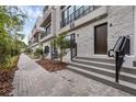 Townhome exterior with textured stone, dark accents, and a paved walkway leading to the front door at 56 W Harding St, Orlando, FL 32806
