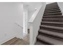 Carpeted staircase with white railing and gray wood flooring creates a clean, modern aesthetic in the foyer at 56 W Harding St, Orlando, FL 32806