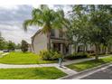 Inviting two-story home with lush green lawn, mature palm tree, and well-maintained landscaping for great curb appeal at 5911 Grassy Point Rd, Winter Garden, FL 34787