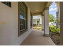 Inviting covered front porch with brick pavers and support columns, perfect for relaxing and enjoying the neighborhood at 5911 Grassy Point Rd, Winter Garden, FL 34787