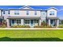 Charming two-story townhome featuring a quaint front porch, blue door, and landscaped front yard at 625 Dogfish Ln, Debary, FL 32713