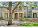 A cozy townhouse with a well-maintained front yard and tree at 7715 Anselmo Ln, Windermere, FL 34786