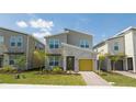 Modern two-story home with a yellow garage door, stone accents, and landscaped yard at 8964 Takeaway Way, Davenport, FL 33896