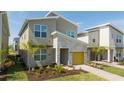 Close up of a modern house with stone accents, a yellow garage door, and fresh landscaping at 8964 Takeaway Way, Davenport, FL 33896