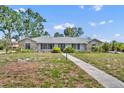 Charming single-story home with stone accents, mature trees, and walkway leading to the front entrance at 1115 Lake Francis Dr, Apopka, FL 32712