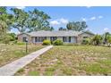 Charming single-story home with stone accents, mature trees, and walkway leading to the front entrance at 1115 Lake Francis Dr, Apopka, FL 32712