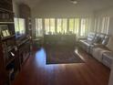 Spacious living room with large windows offering beautiful views and warm hardwood floors at 116 Oakmont Ln, New Smyrna Beach, FL 32168