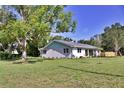 Charming single-story home featuring a metal roof, fresh landscaping, and a spacious front yard with mature trees at 1510 Live Oak St, New Smyrna Beach, FL 32168