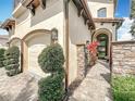 View of a front entrance featuring a modern front door with glass panels, stone accents, and professional landscaping at 16246 Ravenna Ct, Montverde, FL 34756