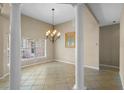 Elegant dining room featuring decorative columns, chandelier, and neutral tile floors at 16729 Tall Grass Ln, Clermont, FL 34711