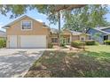 Inviting two-story home with a well-manicured lawn and attached two-car garage at 16729 Tall Grass Ln, Clermont, FL 34711