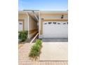 Exterior home featuring a two-car garage, walkway and manicured landscaping at 17404 Chateau Pine Way, Clermont, FL 34711