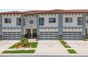 Inviting townhouse showcasing a garage with glass doors, and beautifully maintained landscaping at 2041 Greenbriar Ter, Davenport, FL 33837