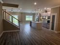Bright living area with hardwood floors, open staircase, and views of the modern kitchen at 2041 Greenbriar Ter, Davenport, FL 33837