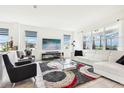 Bright living room with modern decor, large windows, stylish rug, and a comfortable white sectional sofa at 2215 Upland Ln, Apopka, FL 32712