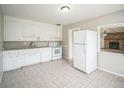 Bright kitchen features granite countertops, white appliances, and tile flooring adjacent to a living room at 2307 Freemason St, Lakeland, FL 33801
