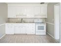 Clean kitchen with white cabinets, granite countertops, tile flooring, and modern appliances at 2307 Freemason St, Lakeland, FL 33801