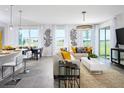Open-concept living room and dining area featuring ample natural light and stylish modern decor with tile flooring at 2524 Raghav Trl, Tavares, FL 32778