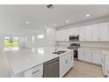 Open-concept kitchen with large island, stainless steel appliances, and ample cabinet space at 2533 Raghav Trl, Tavares, FL 32778